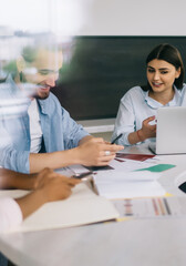 Company team working on solution using gadgets at meeting in office