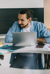 Smiling diverse coworkers chatting at table in office