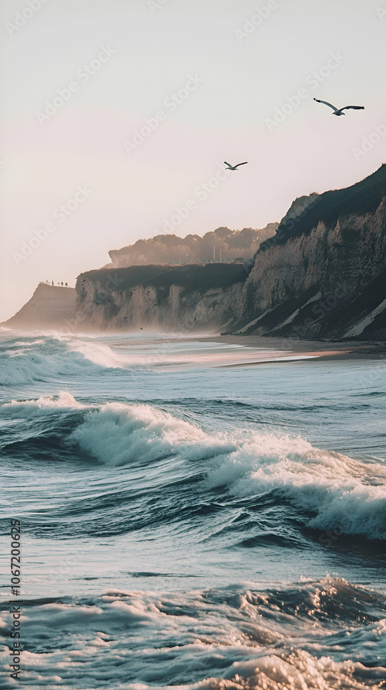 Poster tranquil ocean waves crashing on a sandy beach with cliffs in the background and two seagulls soarin