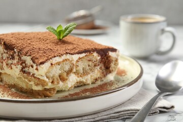 Piece of tasty tiramisu on white table, closeup