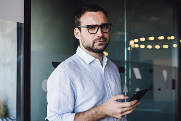 Half length portrait of puzzled male entrepreneur in optical eyeglasses for provide eyes protection...