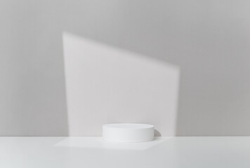 Minimalist Product Display on White Circle Pedestal with Soft Light Play. Studio Photography.