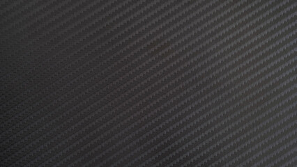 A close-up of a carbon fiber texture, showcasing a repeating pattern of woven fibers. The dark, textured background creates a sleek and modern aesthetic carbon