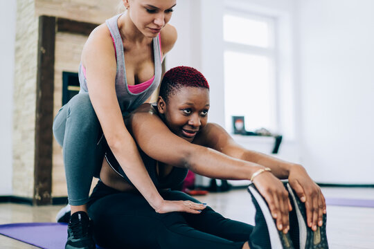 African American female stretching with partner - Powered by Adobe