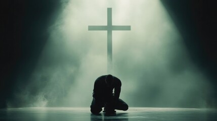 Christian man on his knees praying in front of the cross.