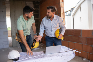 Two accomplished professionals, a male architect and a construction manager, collaborate on-site.	
