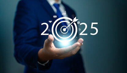 Set goals and strategy for 2025,Businessman holding icon of year 2025 with target arrow on virtual screen,Planning for future growth and success,Development to achieve goals and success,Investment
