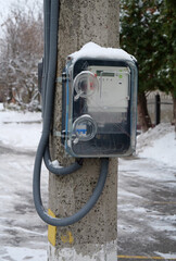 Electric meters for household consumers in private homes hang on a pole