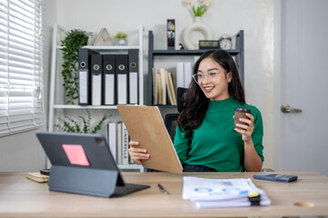 Businesswoman is happy and holding coffee while working from her office