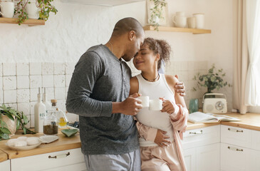 Portrait of sweet cheerful loving african american millennial couple embracing, cuddling, smiling...