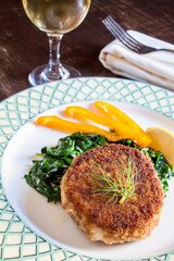 Crispy Fishcake on bed of greens with white wine