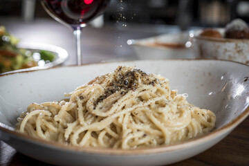 Spaghetti Cacio e Pepe getting seasoned with pepper