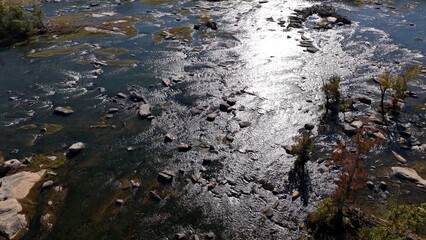 Natural river flowing around rocks and stones in afternoon sunshine Jame River Richmond, VA