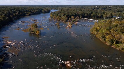 Natural river flowing around rocks and stones in afternoon sunshine Jame River Richmond, VA