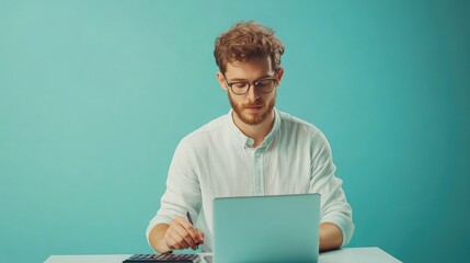 Young man in a light shirt using a calculator and working on a laptop,isolated on solid pastel blue background