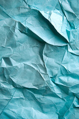 Obraz premium Turquoise crinkled paper texture with intricate folds and creases