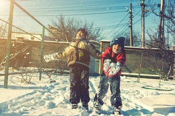 Two boys play with snow. Happy childhood. Brothers on a walk. two kids playing with snow. toned