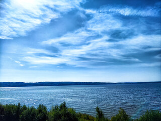 A serene summer day by the tranquil lake with clear blue skies and gentle ripples on the water