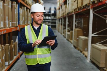 Portrait of warehouseman with clipboard checking delivery, stock in warehouse. Warehouse worker...