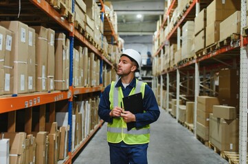 Portrait of warehouseman with clipboard checking delivery, stock in warehouse. Warehouse worker...