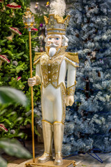 Large decorative floor figure “Nutcracker” on the background of a fir tree.