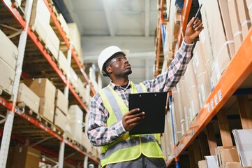 Portrait of african american warehouseman with clipboard checking delivery, stock in warehouse....