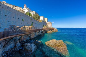 Fototapeta premium Scenic view of Bastia harbor and historic promenade with colorful buildings under a clear blue sky