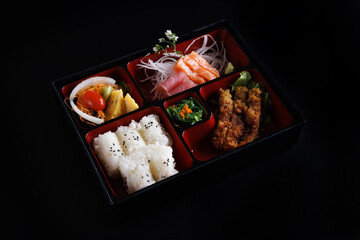 Tonkatsu and sashimi bento set japanese food isolate in black background
