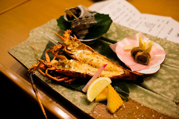 close up of Japanese grilled big king size prawns opened in two sides in half with lemon slice and shellfish at the back