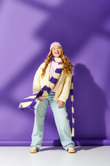 A cheerful plus size woman stands confidently in colorful clothing, expressing joy and style.