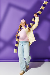 A cheerful plus size woman in cozy clothes shows off her style while enjoying her surroundings.