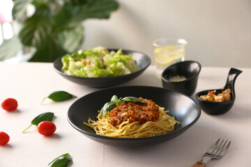 Delicious spaghetti bolognese served on a black plate italian food italian culture