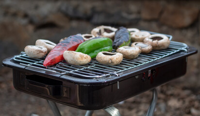 Mushrooms and peppers on the barbecue, healthy vegetable dish on the grill.