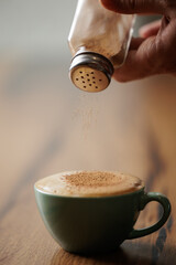 Cup of cappuccino with foam and sprinkled with cinnamon, a delicious coffee for a moment of tranquility and relaxation.