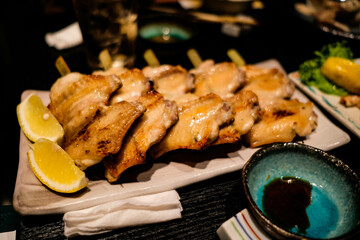 close up of Japanese grilled chicken wings skewers with lemon slice on a plate