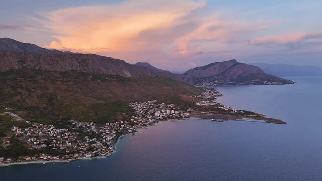 Dramatic colorful clouds above Croatian seashore and mountains at sunset. Omis, Split-Dalmatia county