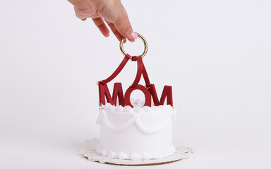 Cake with MOM letters. Mothers Day concept. Overhead view against a white background. Mother's Day Decorated Cake.