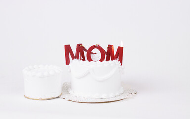 Cake with MOM letters. Mothers Day concept. Overhead view against a white background. Mother's Day Decorated Cake.