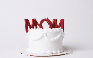 Cake with MOM letters. Mothers Day concept. Overhead view against a white background. Mother's Day Decorated Cake.