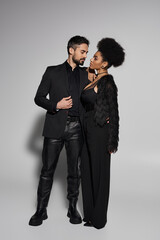 A stylish couple shares an intimate moment, radiating love and elegance in a modern setting.