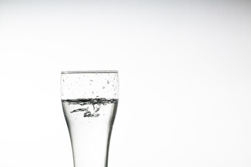 Drinking glass isolated on white background,pouring drinking water in a transparent glass isolated on abstract background with glass table, water resource concept with copy space