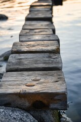 Fototapeta premium A rustic wooden walkway over tranquil water at sunset, glowing in the golden hour. Serene and picturesque scenery.