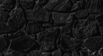 Black stone texture. Stone wall background. Abstract image of dark stones