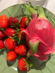 Strawberries and dragonfruit on a green plate