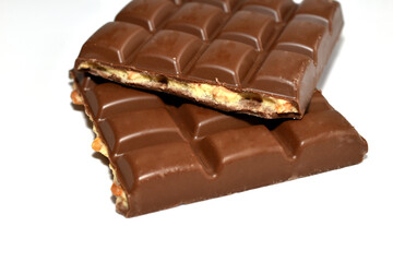 Two bars of broken chocolate with filling lie on a white background.