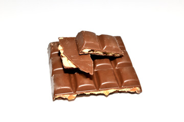 A bar of broken chocolate with filling lies on a white background.