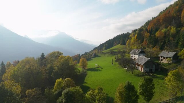 Gozd Martuljek, Slovenia, an alpine hut on the hill with the moutains backdrop, drone footage, aerial video