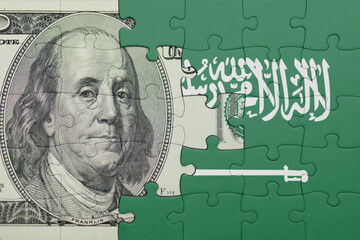 puzzle with the national flag of saudi arabia and the usa dollar money .finance concept