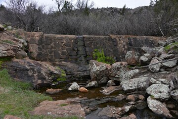 Shallow water with rocks under view of Wichita Mountains in Oklahoma