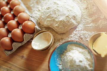 Above, eggs and flour with dough for baking, cooking or bread production in kitchen. Food, butter and nutrition with rolling pin and ingredients in home for dessert, culinary and pastry preparation